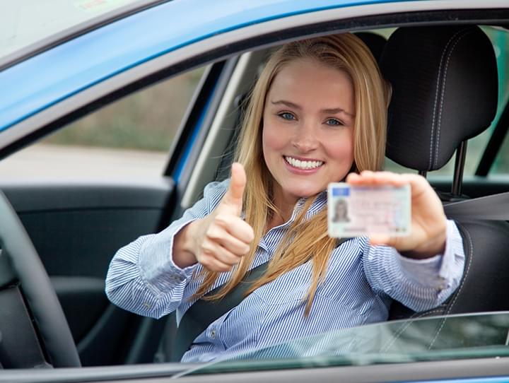 Frau mit Führerschein in der Hand
